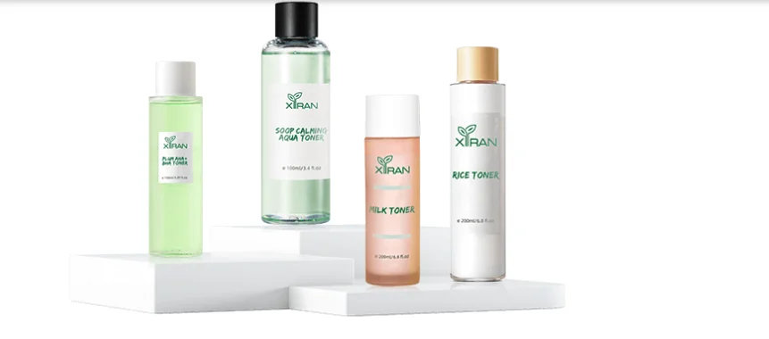 Four Xiran toner bottles, including Play Toner, Soothing Aqua Toner, Milk Toner, and Rice Toner, arranged on white platforms.